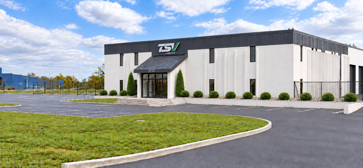 Architectural rendering of TSV Logistics’ new Springfield facility with white offices, black shop doors, green entry arborvitae and natural stone landscaping.